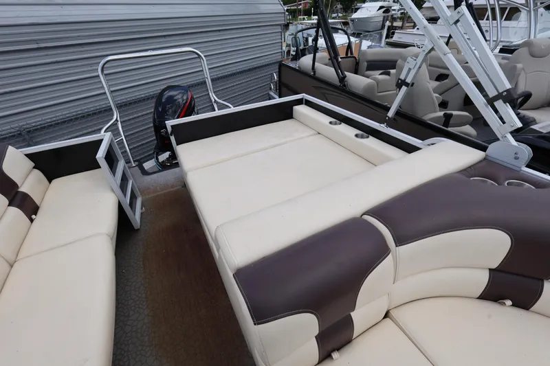 Slide: The Image of 2021 Lexington 525 cc boat interior with beige and brown seating, outboard motor, and metal railings. - 17