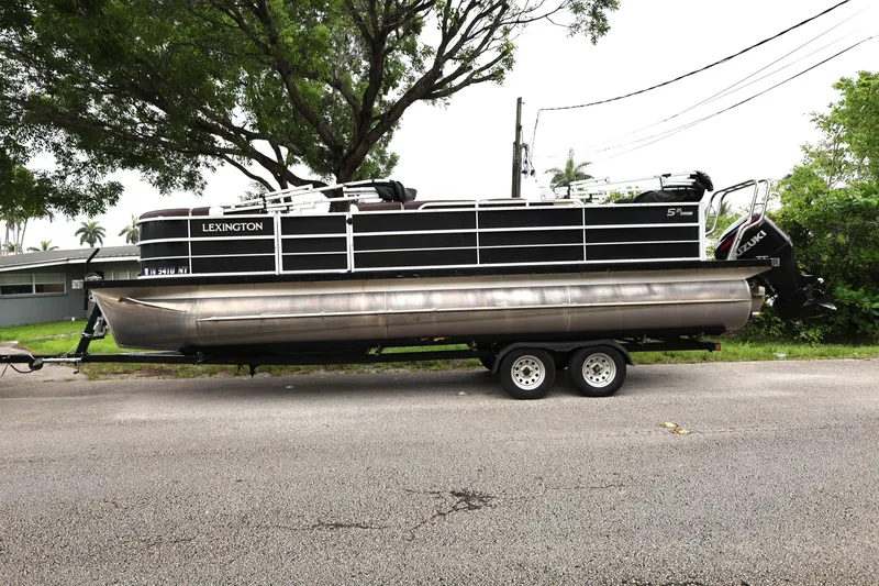 Slide: The Image of 2021 Lexington 525 cc pontoon boat on trailer, parked on roadside. - 2