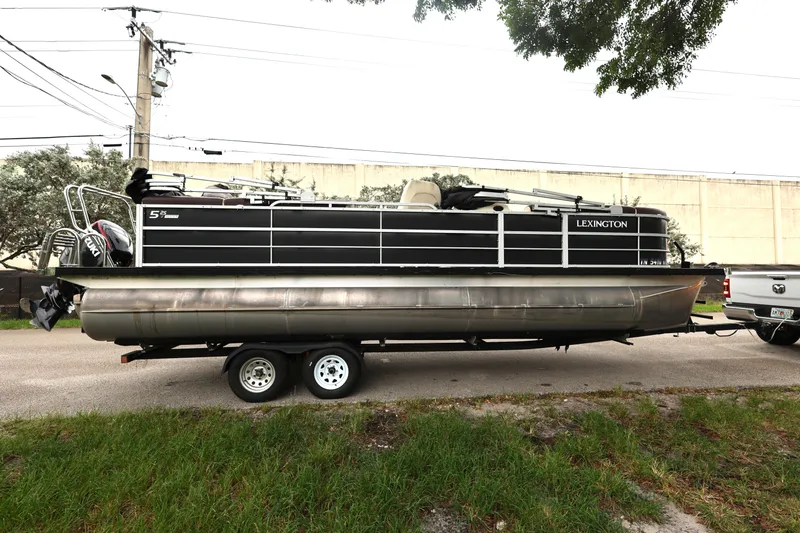 Slide: The Image of 2021 Lexington 525 cc pontoon boat on trailer, parked beside a truck. - 5