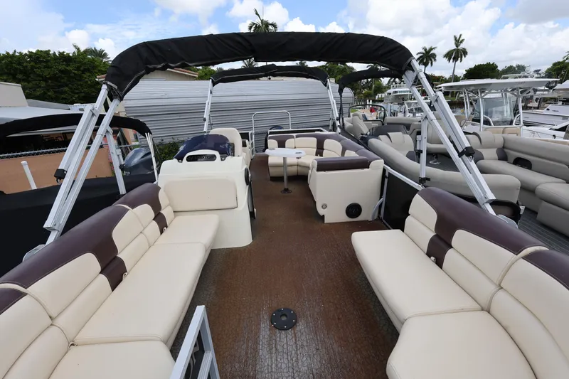 Slide: The Image of 2021 Lexington 525 cc pontoon boat with spacious seating and canopy, docked under a cloudy sky. - 9