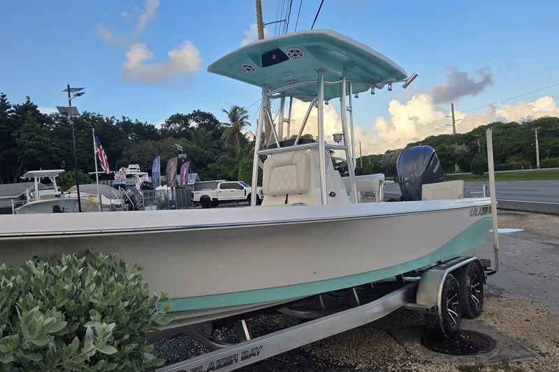 Slide: The Image of 2026 Blazer PureBay 2400 boat on trailer, displayed outdoors under a blue sky. - 11