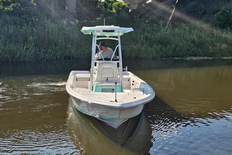 Slide: The Image of 2026 Blazer PureBay 2400 boat navigating a calm river under sunlight. - 19