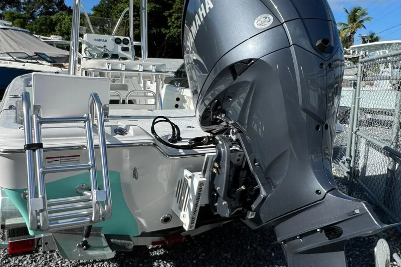 Slide: The Image of 2026 Blazer PureBay 2400 boat with Yamaha outboard motor and ladder, parked outdoors. - 2