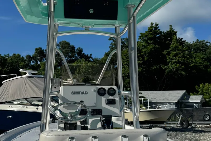 Slide: The Image of 2026 Blazer PureBay 2400 boat console with Simrad electronics, docked under clear blue sky. - 5