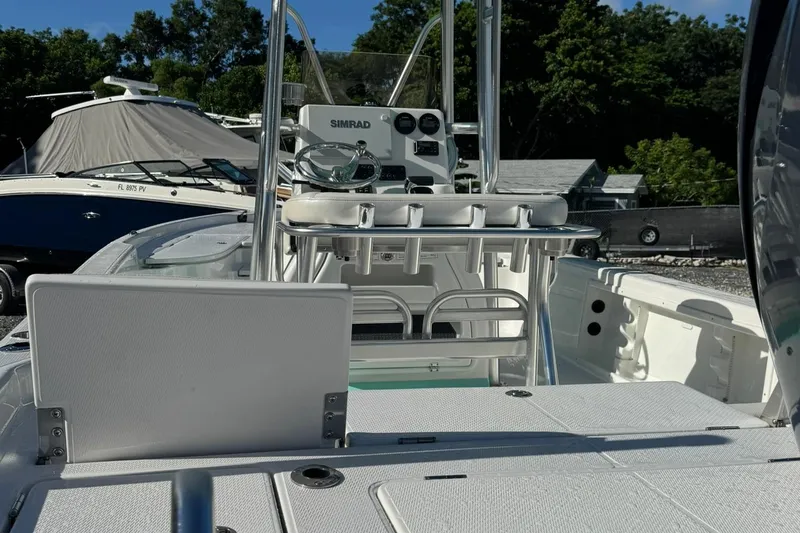 Slide: The Image of 2026 Blazer PureBay 2400 boat interior with steering console and seating, docked outdoors. - 7