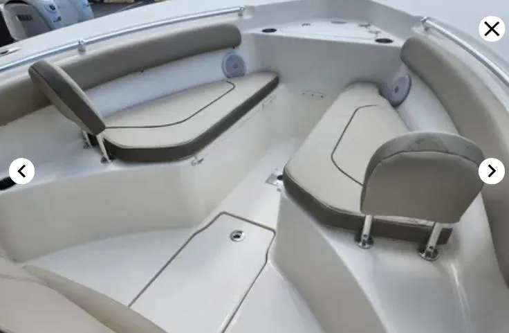 Slide: The Image of 2023 Key West 244 CC boat interior with cushioned seating and storage compartments. - 10