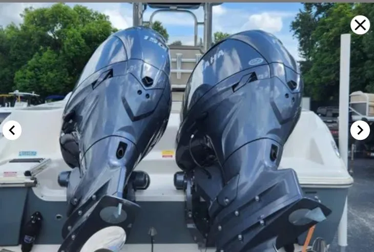 Slide: The Image of 2023 Key West 244 CC boat with dual Yamaha outboard engines, parked outdoors. - 2