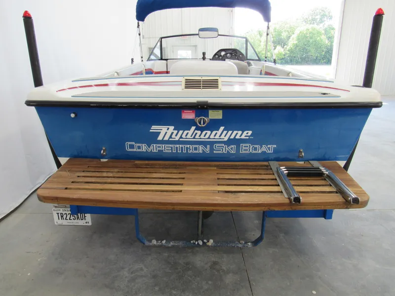 Slide: The Image of 1993 Hydrodyne Comp ski boat with wooden platform and blue exterior in a garage setting. - 3