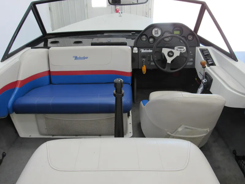 Slide: The Image of 1993 Hydrodyne Comp boat interior with blue and red seating, steering wheel, and dashboard controls. - 4