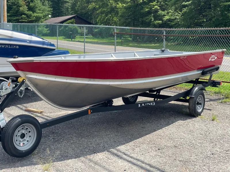 The Image of 2026 Lund SSV-16 boat on trailer, red and silver, parked outdoors. - 1