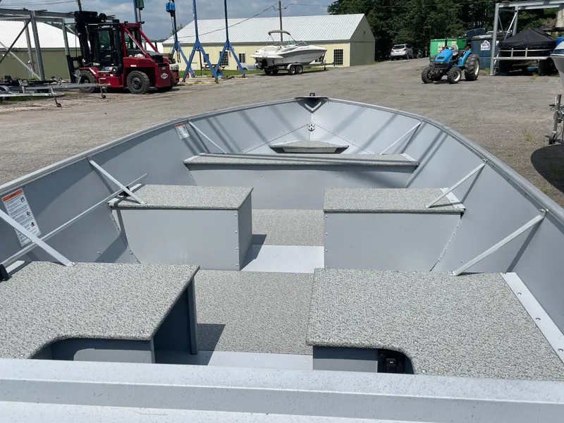 Slide: The Image of 2026 Lund SSV-16 boat interior with seating, parked in a marina lot. - 4