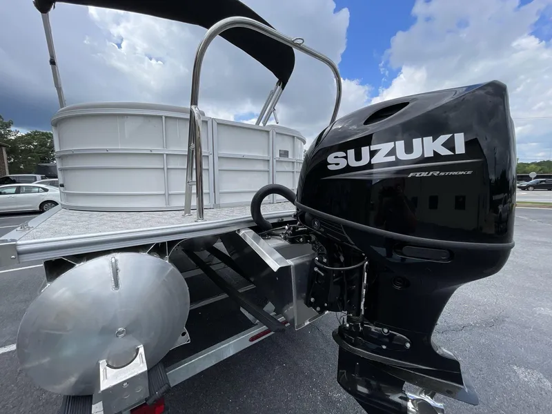 Slide: The Image of 2025 South Bay 222RSLE pontoon boat with Suzuki outboard motor, parked outdoors. - 5