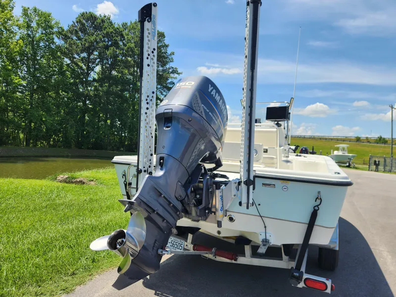 Slide: The Image of 2011 Ranger 220 Bahia boat with Yamaha outboard motor on trailer, parked near a pond. - 3
