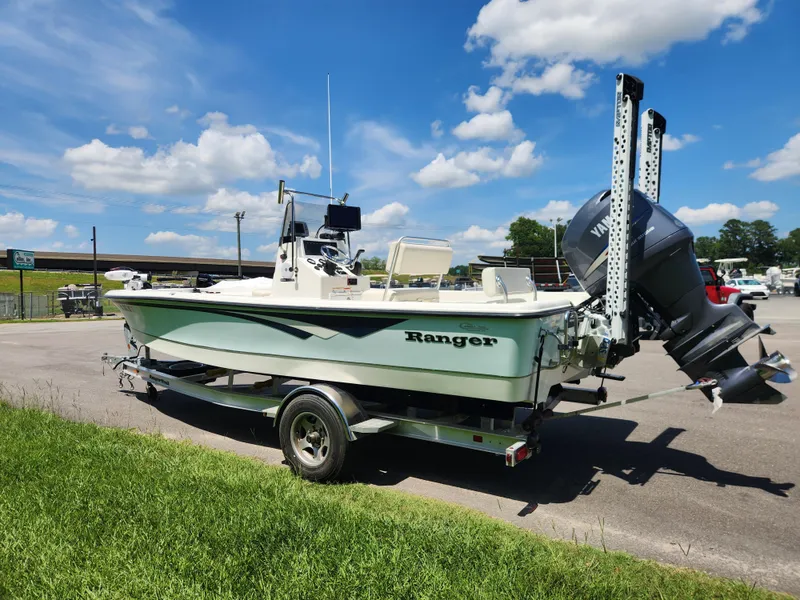 Slide: The Image of 2011 Ranger 220 Bahia boat on trailer, parked outdoors under a clear blue sky. - 4