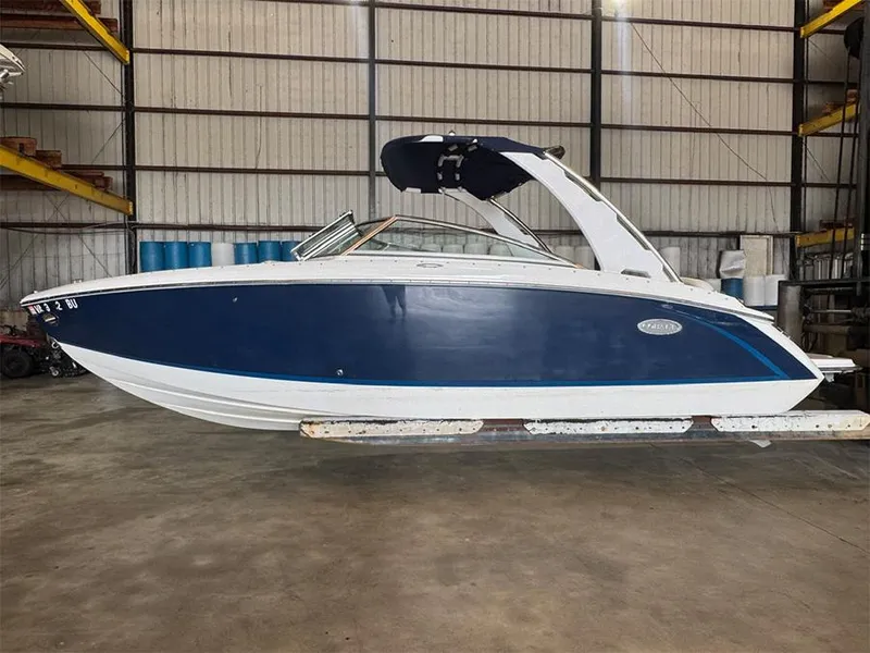 Slide: The Image of 2014 Cobalt R5 boat in warehouse, blue and white exterior, side view. - 0