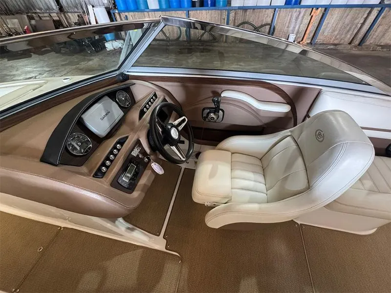 Slide: The Image of Interior of a 2014 Cobalt R5 boat with beige leather seating and dashboard controls. - 11