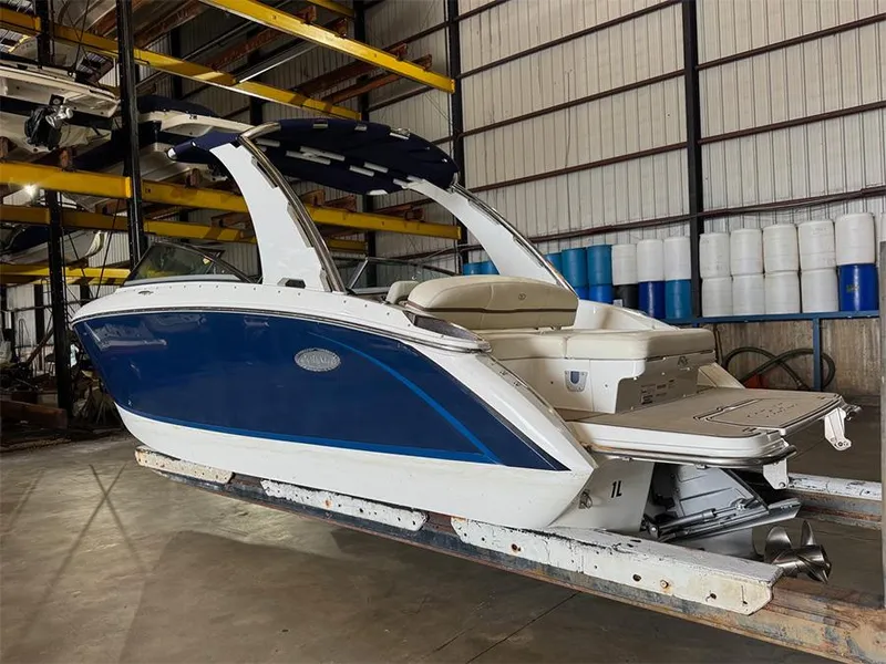 Slide: The Image of 2014 Cobalt R5 boat in storage, blue and white exterior, indoor warehouse setting. - 2