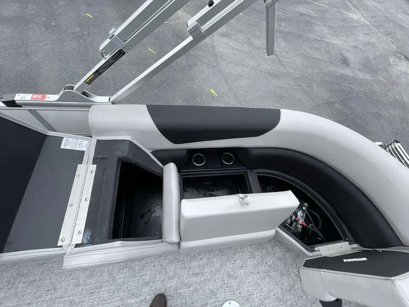 Slide: The Image of 2025 South Bay 222 RSLE boat interior with open storage compartment and seating. - 16