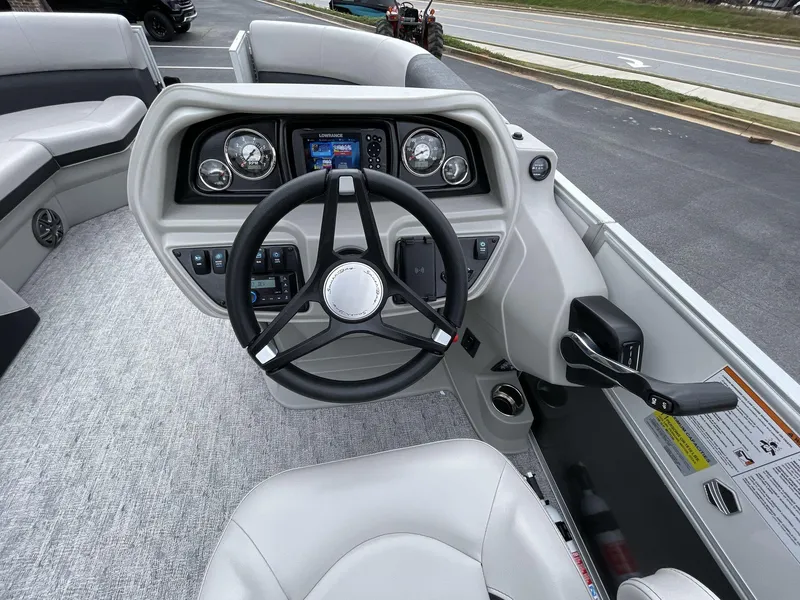 Slide: The Image of 2025 South Bay 222 RSLE boat dashboard with steering wheel and control panel. - 24