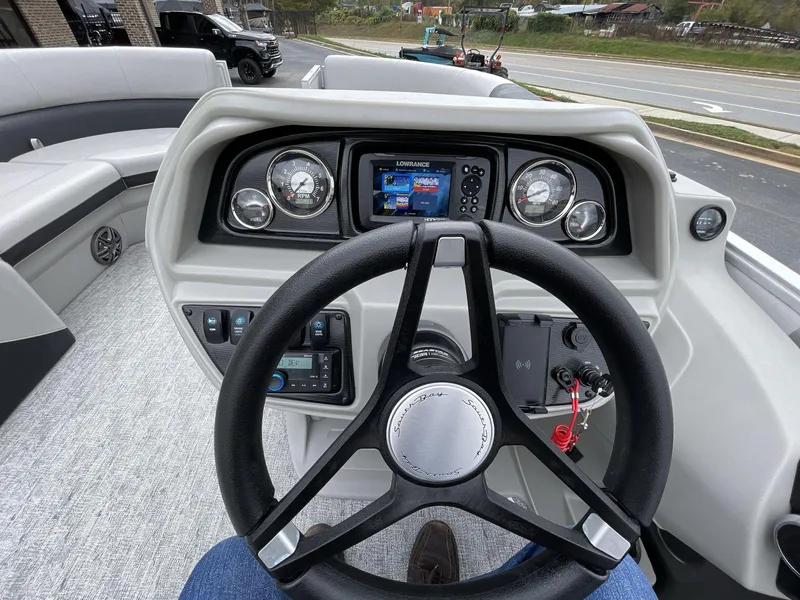 Slide: The Image of 2025 South Bay 222 RSLE boat dashboard with steering wheel and control panel. - 26