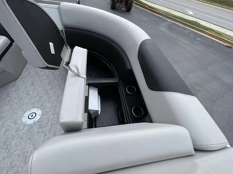 Slide: The Image of 2025 South Bay 222 RSLE boat interior with open storage compartment and cup holders. - 30