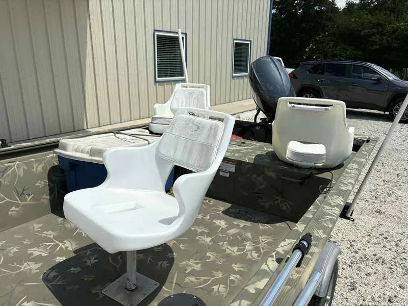 Slide: The Image of 2023 Tracker Grizzly 1648 Jon boat with white seats and camouflage design. - 9