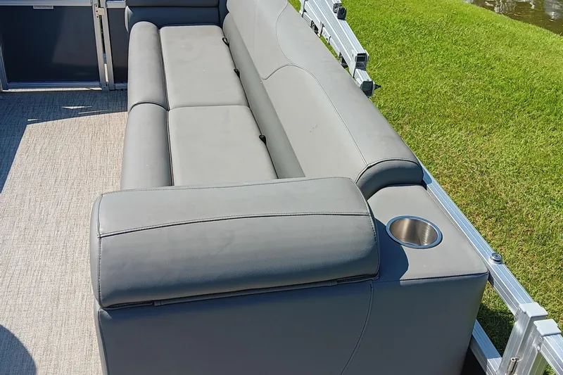Slide: The Image of 2022 Avalon VLS Quad Lounge with gray seating and cup holder, set against green grass. - 14