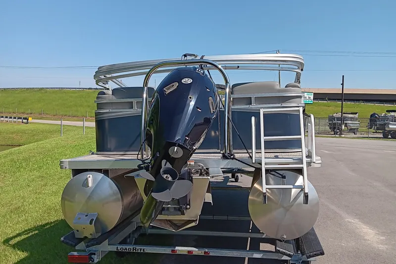 Slide: The Image of 2022 Avalon VLS Quad Lounge pontoon boat on trailer, rear view with motor. - 3