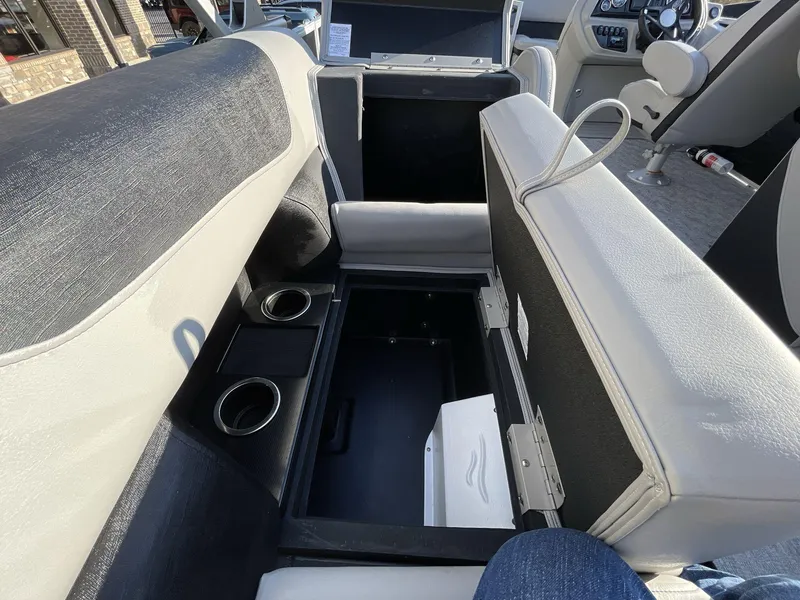 Slide: The Image of Interior of 2025 South Bay 222RSLE boat showing storage compartment and cup holders. - 2