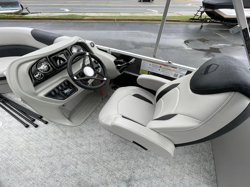 Slide: The Image of 2025 South Bay 222RSLE boat interior with steering wheel and captain's chair. - 23