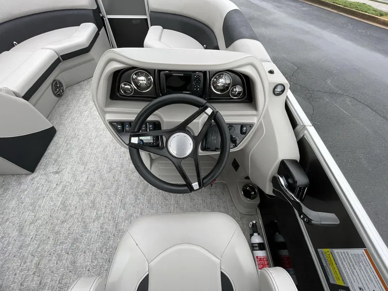 Slide: The Image of Interior view of 2025 South Bay 222RSLE boat cockpit with steering wheel and controls. - 25