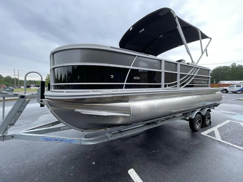 Slide: The Image of 2025 South Bay 222RSLE pontoon boat on trailer, parked outdoors. - 9