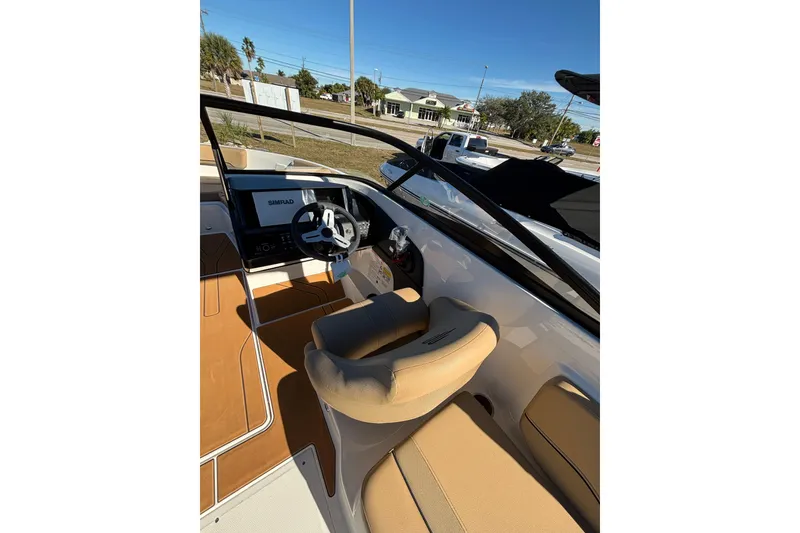 Slide: The Image of 2025 Bayliner V20 boat interior with steering wheel and beige seating. - 9