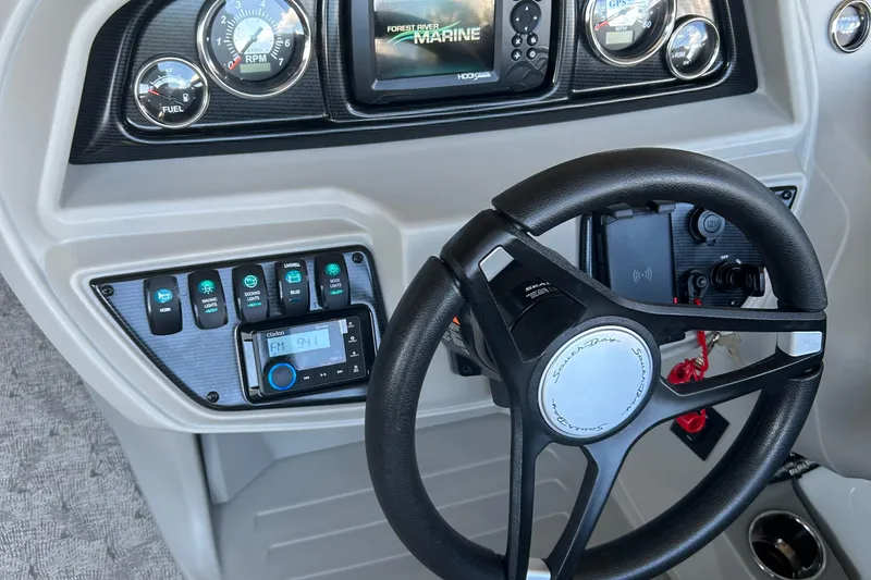 Slide: The Image of 2025 South Bay 222RSLE boat dashboard with steering wheel and control panel. - 2
