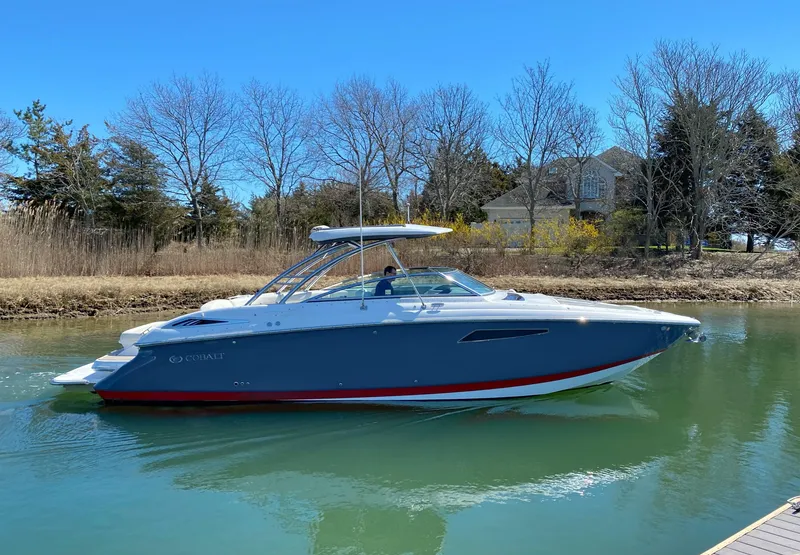 Slide: The Image of 2018 Cobalt R35 boat on calm water near a wooded shoreline. - 1