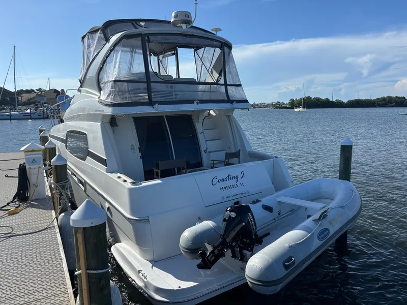 Slide: The Image of Open wooden cabinet with binders inside on a 2001 Silverton 410 Sport Bridge yacht. - 34