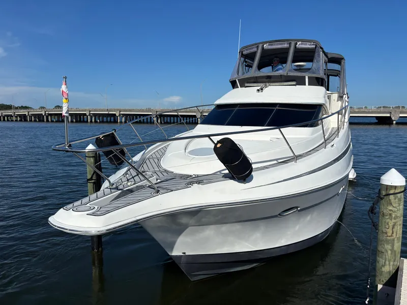 Slide: The Image of 2001 Silverton 410 Sport Bridge yacht deck with chairs and cooler, docked by the water. - 36