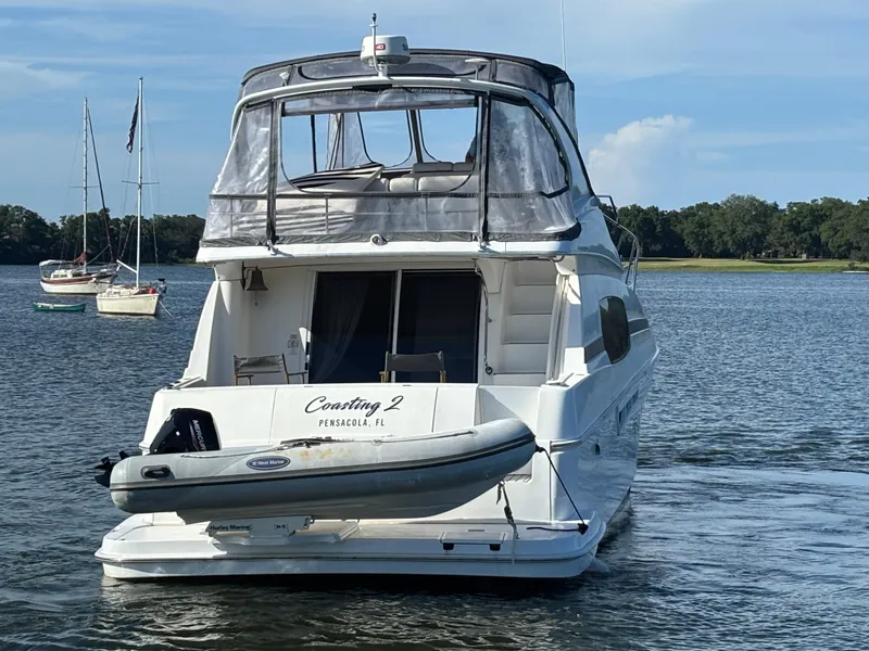 Slide: The Image of 2001 Silverton 410 Sport Bridge yacht docked by a pier under clear blue skies. - 37