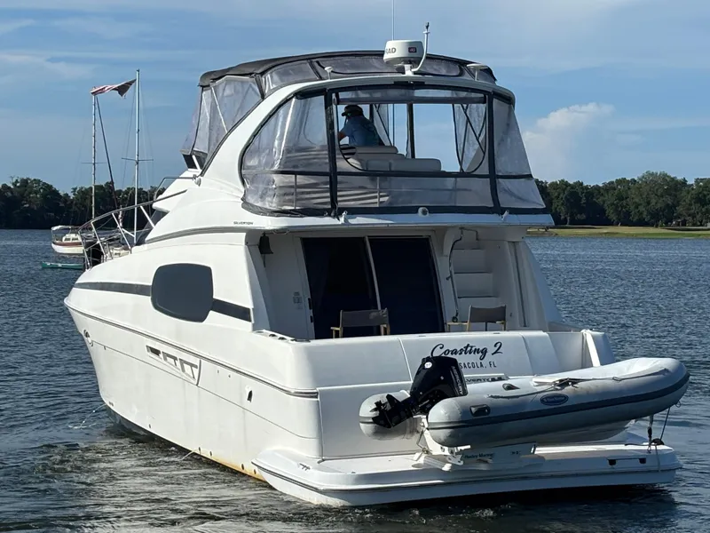 Slide: The Image of 2001 Silverton 410 Sport Bridge yacht on water, with inflatable boat attached. - 38