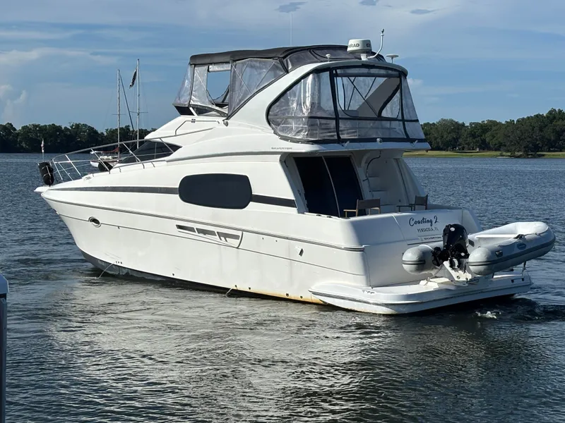 Slide: The Image of 2001 Silverton 410 Sport Bridge yacht on water with inflatable boat attached. - 39