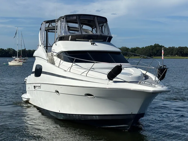 Slide: The Image of 2001 Silverton 410 Sport Bridge yacht on calm water, featuring a sleek design and spacious deck. - 40