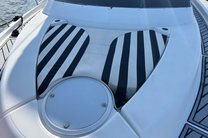 Slide: The Image of 2001 Silverton 410 Sport Bridge boat deck with striped cushions and circular hatch. - 59