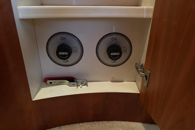 Slide: The Image of 2001 Silverton 410 Sport Bridge interior cabinet with control knobs and tools. - 73