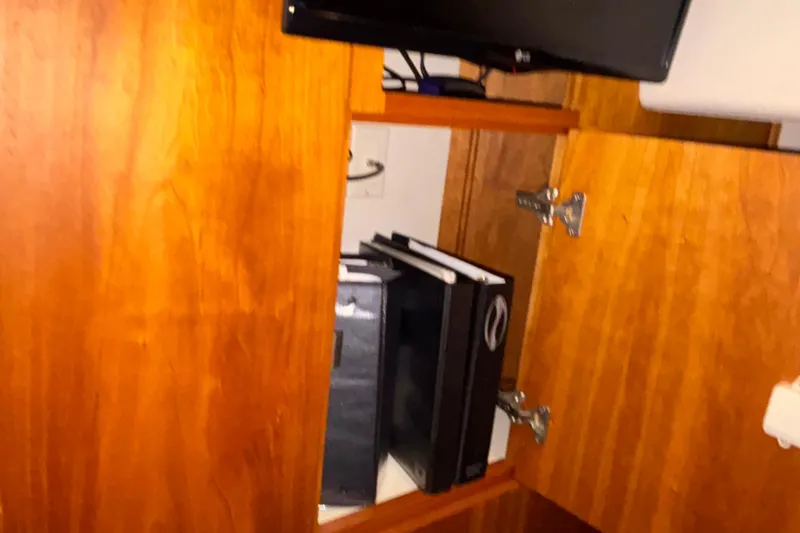 Slide: The Image of Open wooden cabinet with binders inside on a 2001 Silverton 410 Sport Bridge. - 84