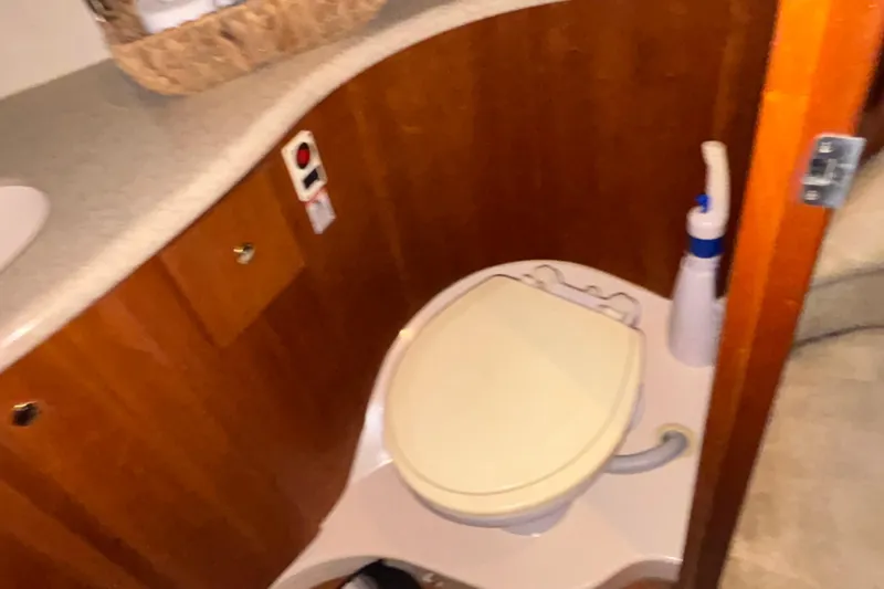 Slide: The Image of 2001 Silverton 410 Sport Bridge bathroom with toilet and cleaning supplies. - 88