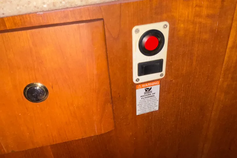 Slide: The Image of Red button and warning label on 2001 Silverton 410 Sport Bridge wooden panel. - 89