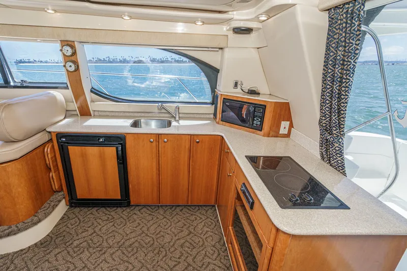 Slide: The Image of 2003 Meridian 341 Sedan yacht kitchen with wood cabinetry, sink, stove, and ocean view. - 26