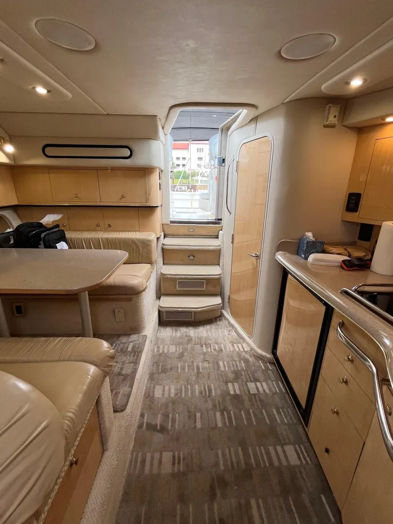 Slide: The Image of Interior of 2001 Sea Ray 340 Amberjack yacht, featuring kitchen and seating area. - 10