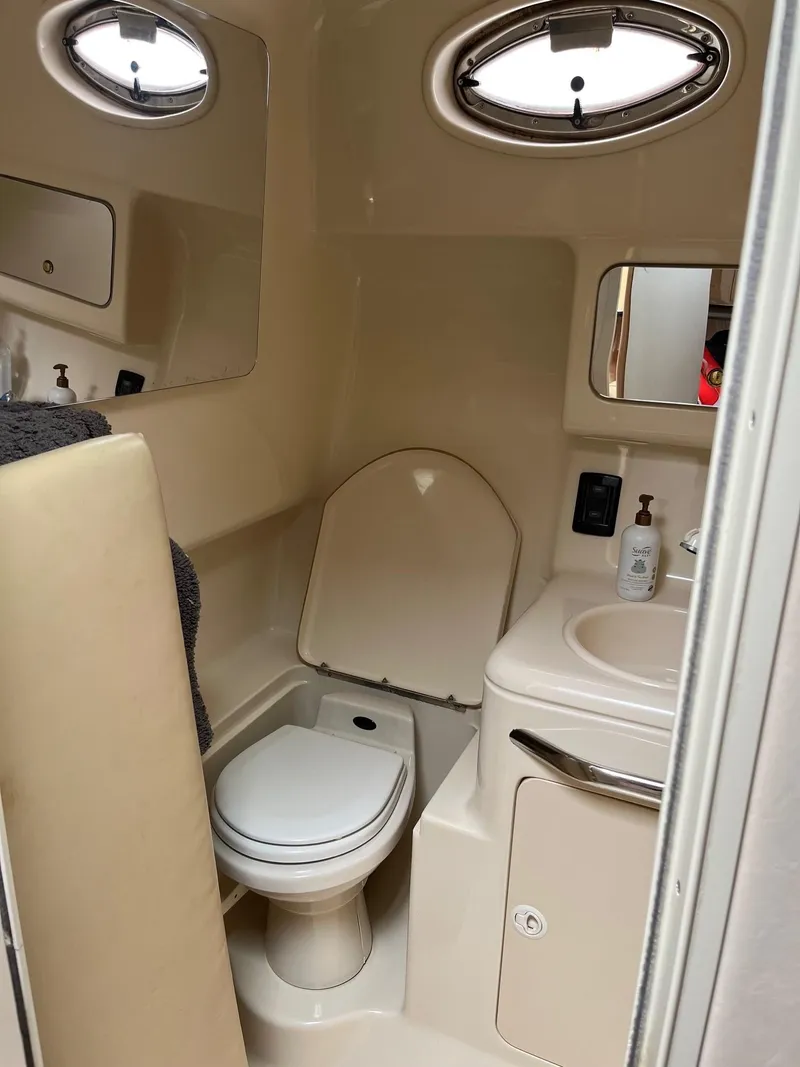 Slide: The Image of 2001 Sea Ray 340 Amberjack boat bathroom with toilet, sink, and porthole window. - 13