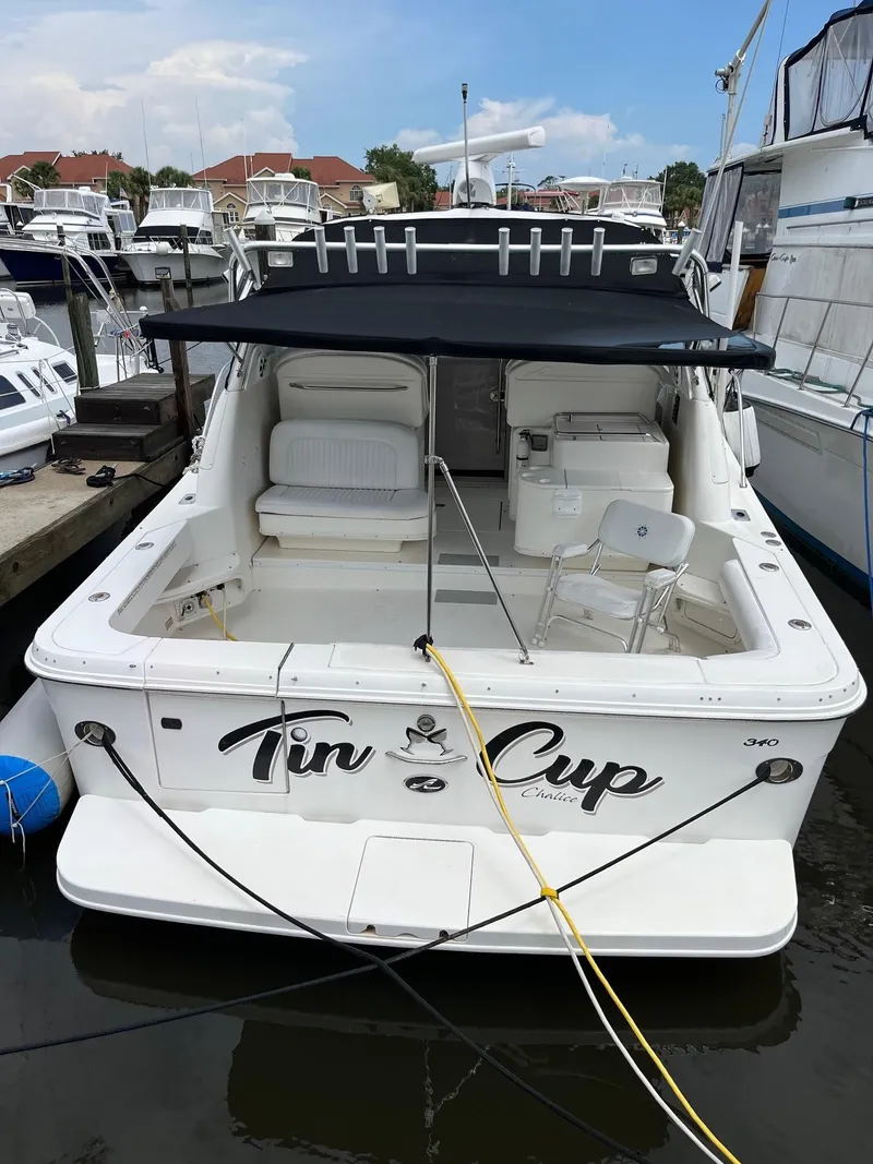 Slide: The Image of 2001 Sea Ray 340 Amberjack boat docked, featuring spacious seating and canopy. - 5